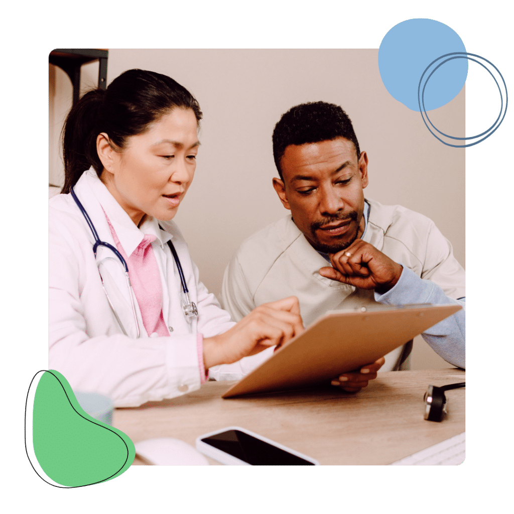 A female doctor and male nurse reviewing a file.